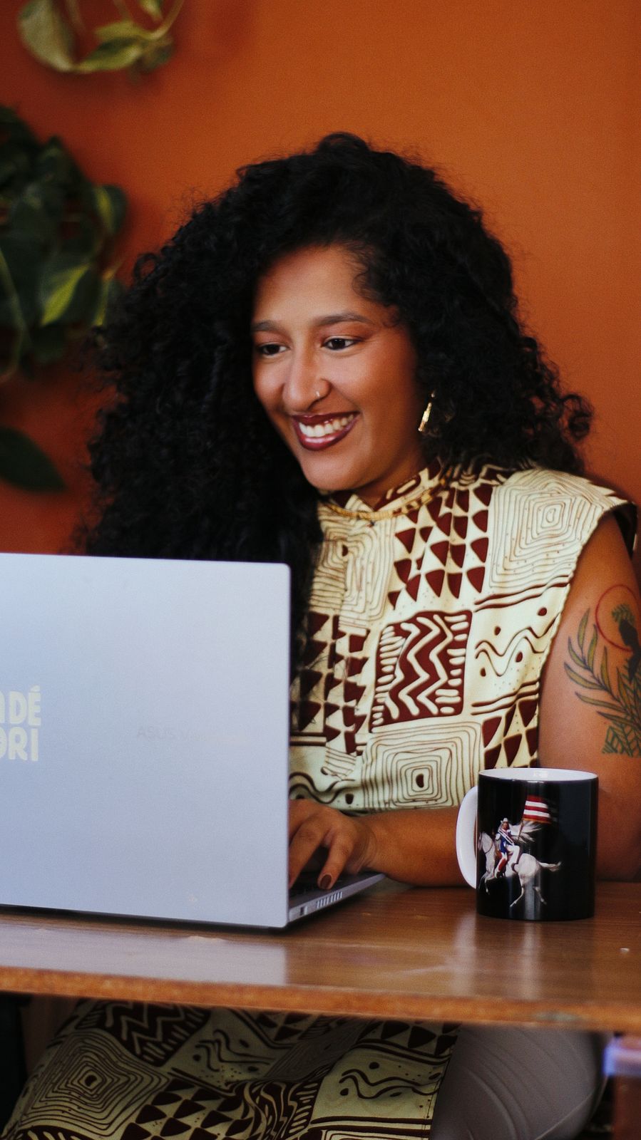 Marina Niambi em atendimento online, sorrindo diante do notebook